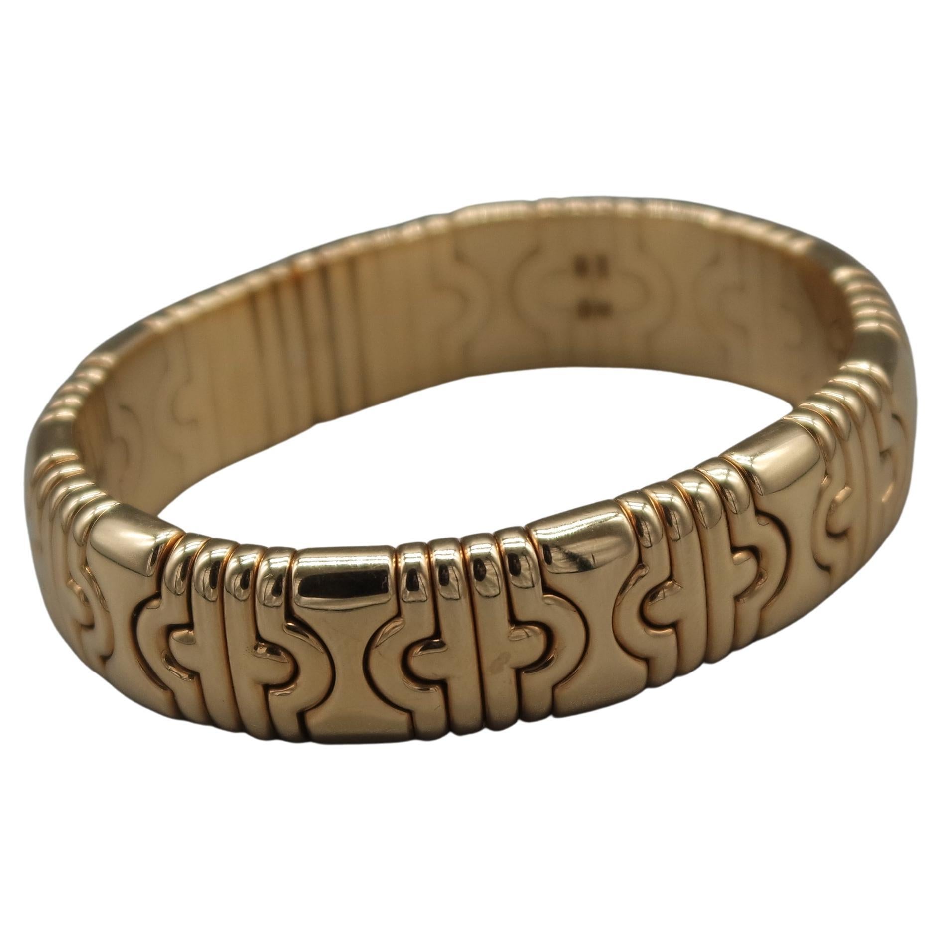 This exquisite authentic Bulgari bangle bracelet of immaculate design and artistic craftsmanship is of Italian provenance, crafted in solid 18K yellow gold, weighing app. 88.45 grams. Depicting delicate geometrical motives throughout the bracelet,
