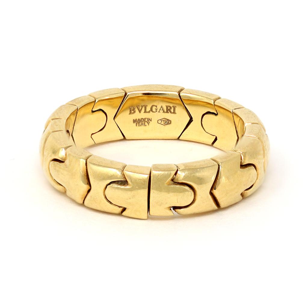 A signed Bvlgari Diamond band ring in 18K yellow gold, circa 1980. Showcasing the Parentesi design, inspired by the travertine junction of the Eternal City of Rome's pavements, this band ring features 10 full cut round Diamonds weighing 0.10ct