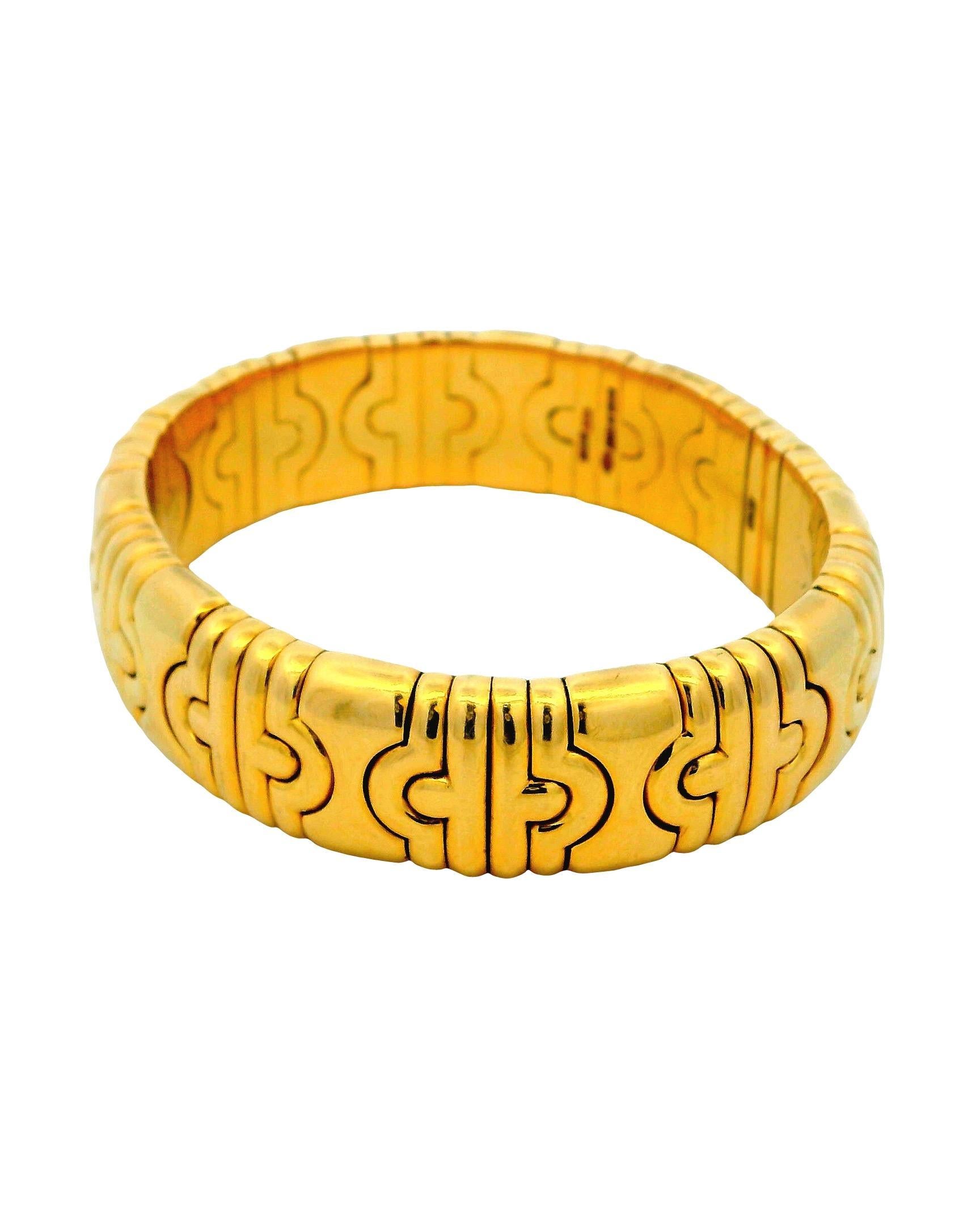 Le bracelet manchette audacieux est un bijou étonnant qui met en valeur des motifs géométriques complexes. Réalisé en or jaune 18 carats, il affiche une série de formes imbriquées qui créent un design visuellement captivant. La finition polie