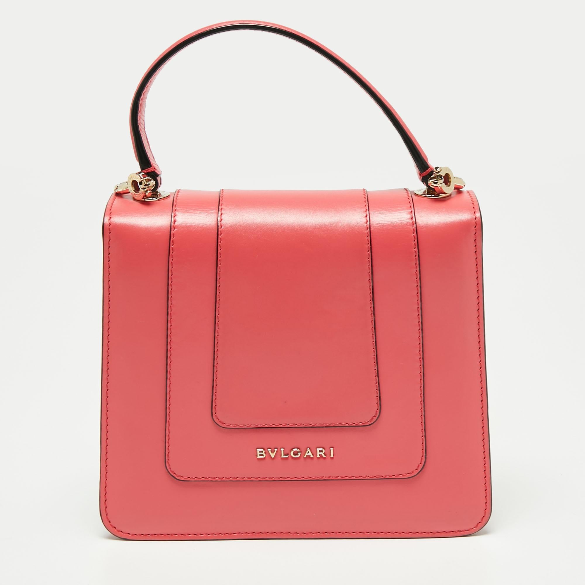 Add a dazzling element to your style with this stunning Bvlgari creation. Crafted from pink leather, the bag has a flap with the iconic Serpenti head closure. The bag has a fabric-lined interior, a top handle, and a strap for an easy carrying