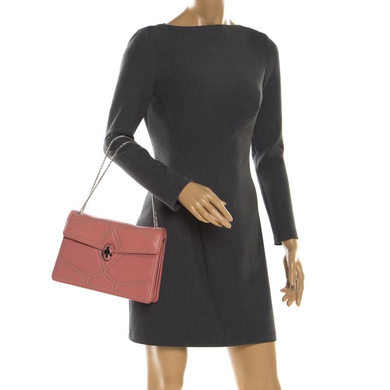 Dazzle the eyes that fall on you when you swing this stunning Bvlgari creation. Crafted from leather in a breathtaking pink hue, the shoulder bag is styled with a flap that has the iconic Serpenti head closure and studs. The bag has a spacious