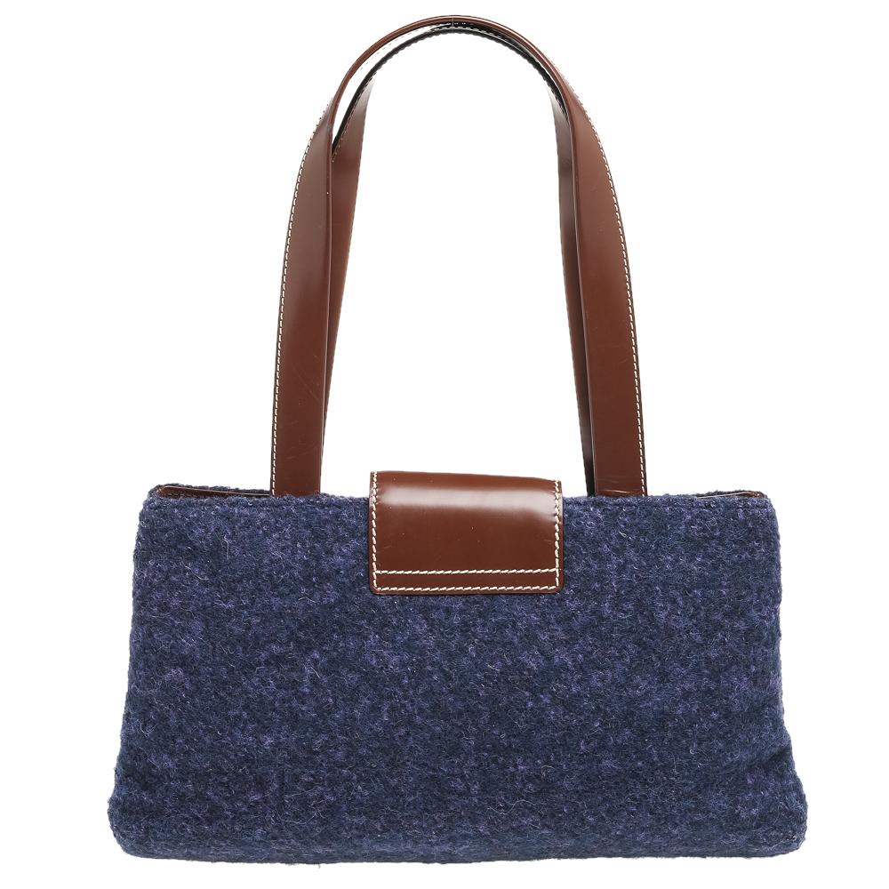 Every modern-day wardrobe needs a bag like this Bvlgari one. Crafted from purple-hued wool and dark brown leather, this shoulder bag is sleek and sophisticated. It has dual handles, gold-tone hardware and a spacious Alcantara interior.