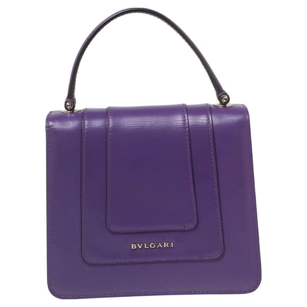 Add a dazzling element to your style with this stunning Bvlgari creation. Crafted from purple leather, the bag has a flap with the iconic Serpenti head closure. The bag has a lined interior, a top handle, and a strap for an easy carrying