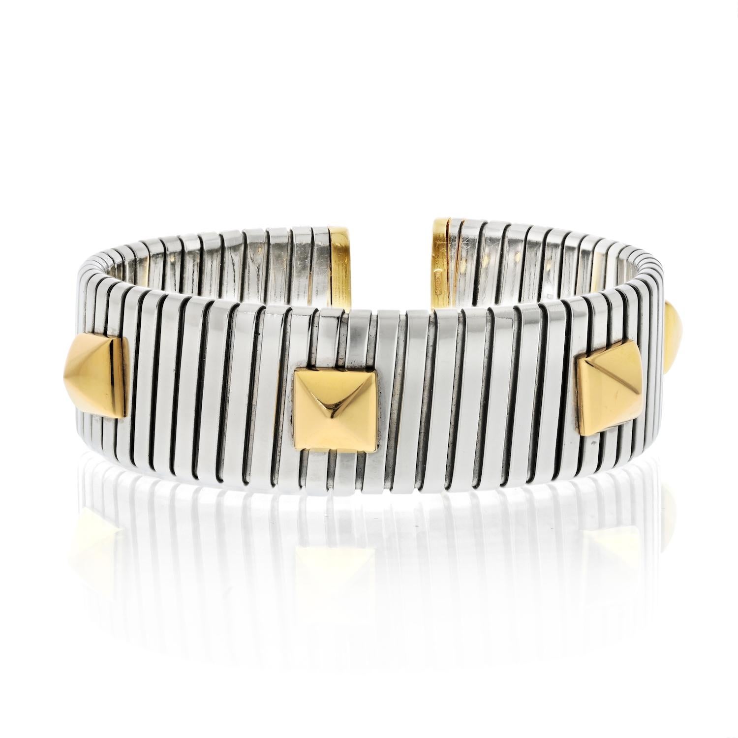 Dieses auffällige Armband von Bvlgari aus gefedertem Stahl zeichnet sich durch ein elegantes zweifarbiges Design aus, das mit kühnen Pyramidenmotiven akzentuiert ist und einen modernen Touch erhält. Das Armband hat einen Durchmesser von 6 cm, ist