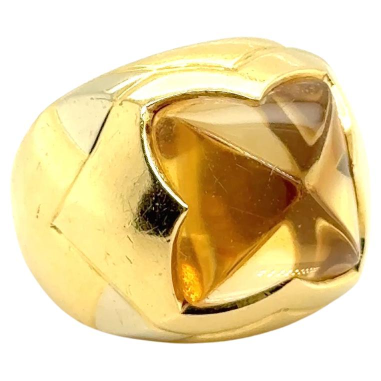 The BVLGARI Pyramid Ring in 18 Karat Yellow Gold with Citrine embodies a masterful fusion of bold elegance and timeless artistry. Its striking pyramid-shaped design is a tribute to the brand's iconic, architectural aesthetic, offering a modern take