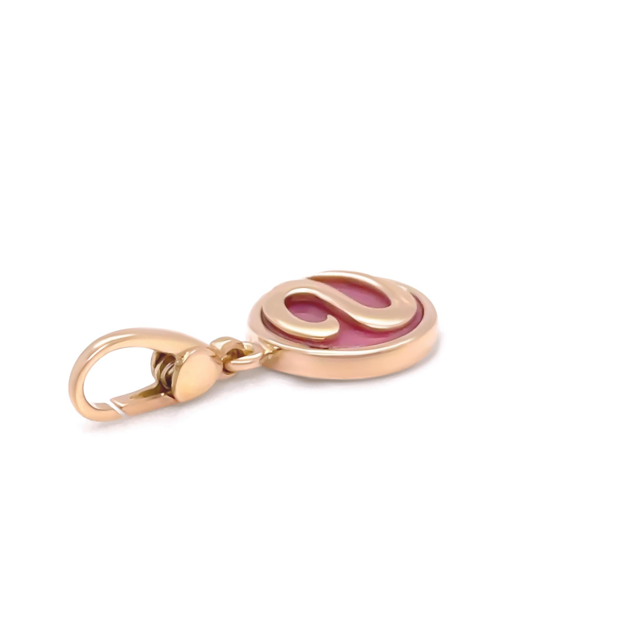 Questo raro e da collezione ciondolo Bvlgari della linea Charme Tematica è realizzato in oro giallo 18 carati e presenta una vibrante rodocrosite rosa al centro. La finitura lucida e il design minimalista riflettono la miscela di lusso ed eleganza