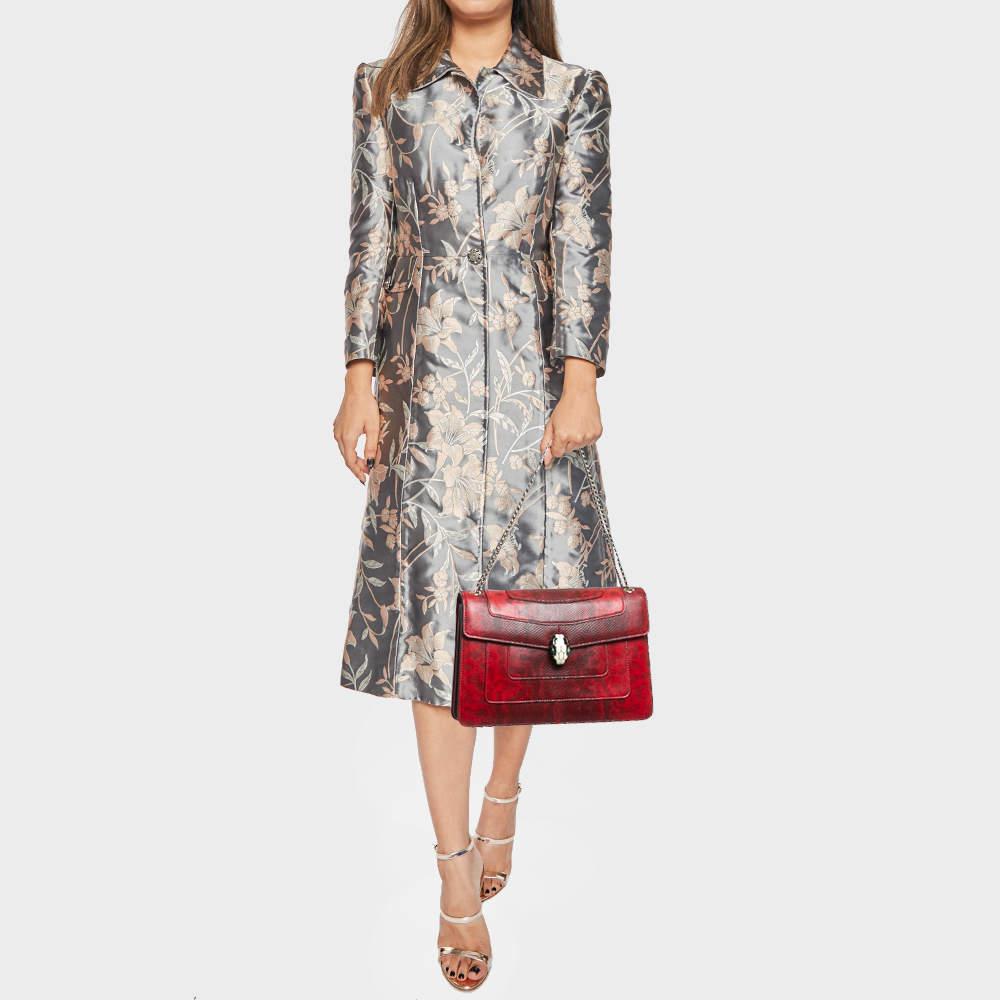 Add a dazzling element to your style with this stunning Bvlgari creation. Crafted from karung leather in a red hue the shoulder bag is styled with a flap that has the iconic Serpenti head closure. The bag has a fabric interior and a gorgeous gold