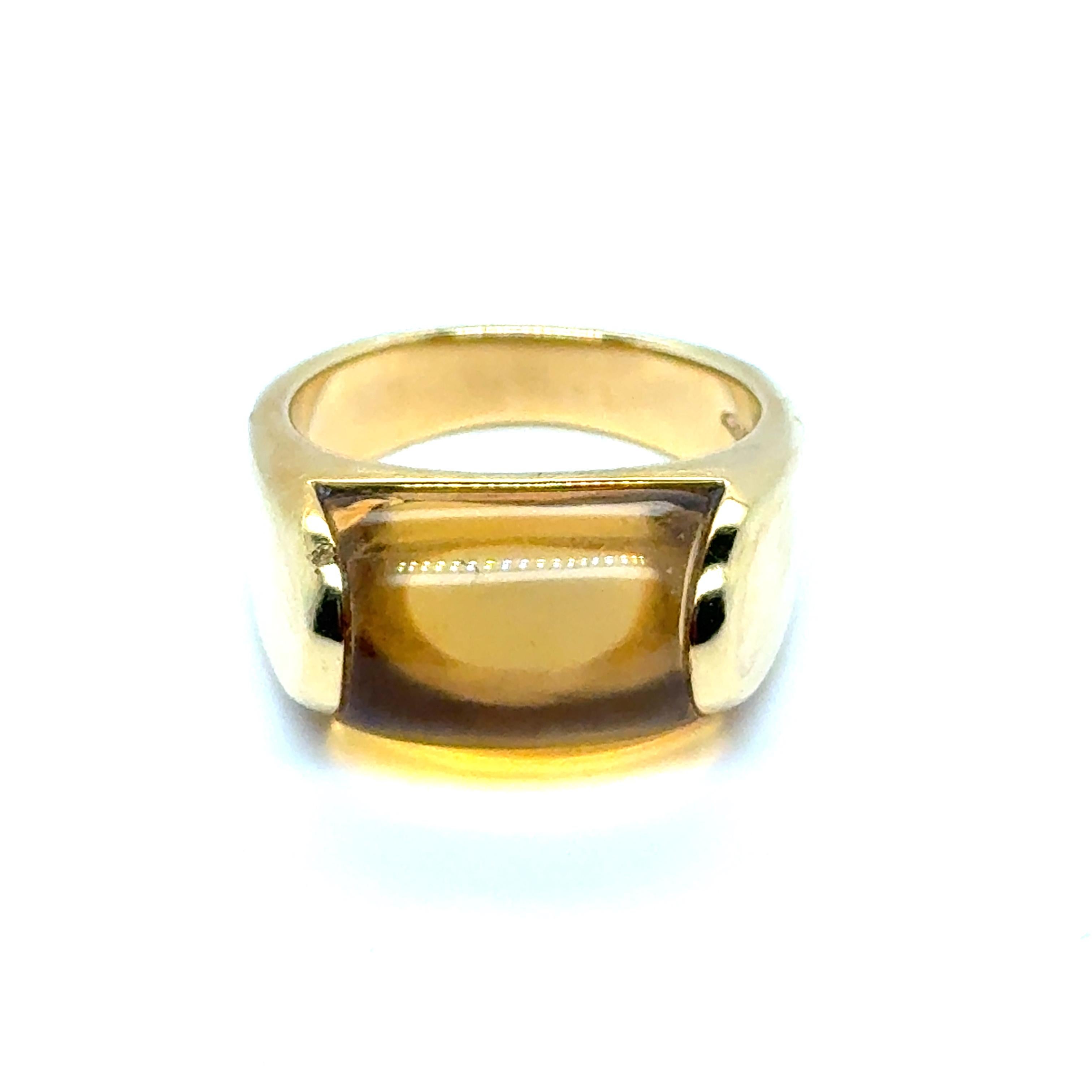 This exquisite Bvlgari ring, crafted from 18 Karat yellow gold, showcases a stunning rectangular citrine gemstone. The citrine's warm, amber hue and polished finish add a touch of vibrant elegance. The thick, shiny gold band perfectly complements