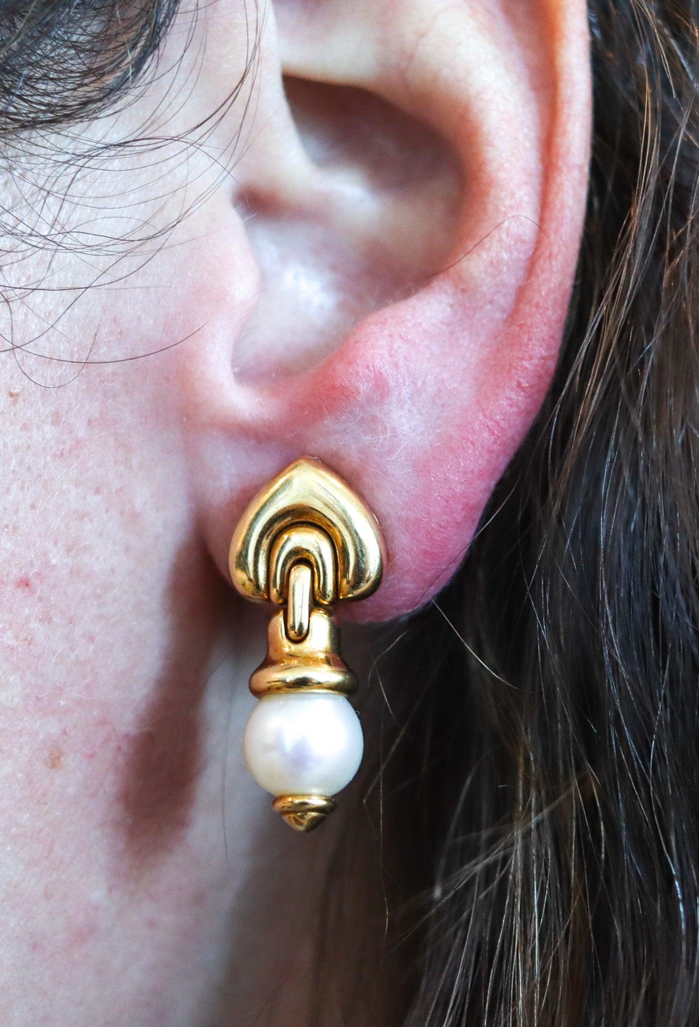 Gems set earring designed by Bvlgari.

Great pair of classic clips-on dangle earrings, created in Roma Italy by the jewelry house of Bvlgari. This dangle-drop pair have been carefully crafted with modernist patterns in solid yellow gold of 18 karats