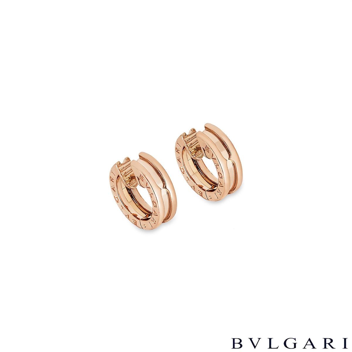 A pair of 18k rose gold hoop earrings by Bvlgari from the B.zero1 collection. The hoop earrings are each display the iconic Bvlgari Bvlgari logo engraved around the outer edges. The earrings measure 15mm in height and are 5mm wide and feature post