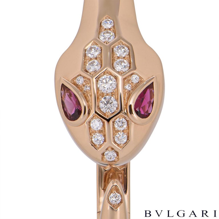 An 18k rose gold diamond and rubellite Bvlgari bracelet from the Serpenti collection. The bracelet features the iconic Bvlgari serpenti snake, the head motif is set with 17 pave round brilliant cut diamonds and 2 rubellite eyes, whilst the tail