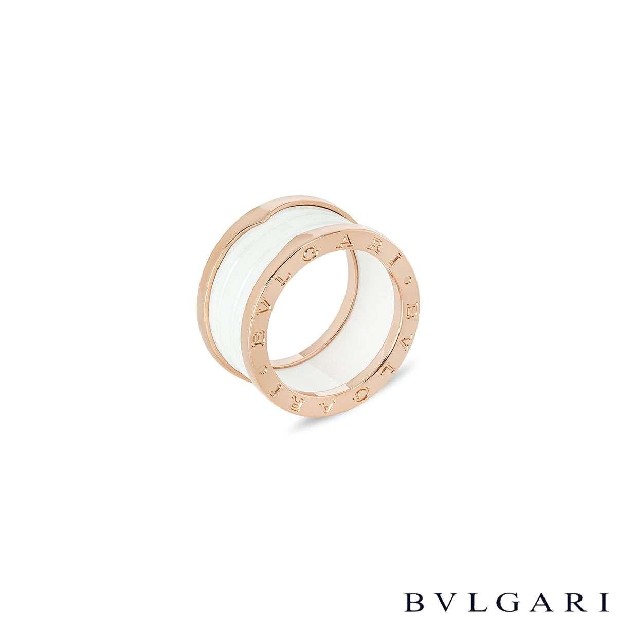 A stunning 18k rose gold ring by Bvlgari, from the B.Zero1 collection. Features a white ceramic spiral design, encased by rose gold bands on the top and bottom. The iconic 'BVLGARI BVLGARI' logo is engraved around the edges of the bands. This ring