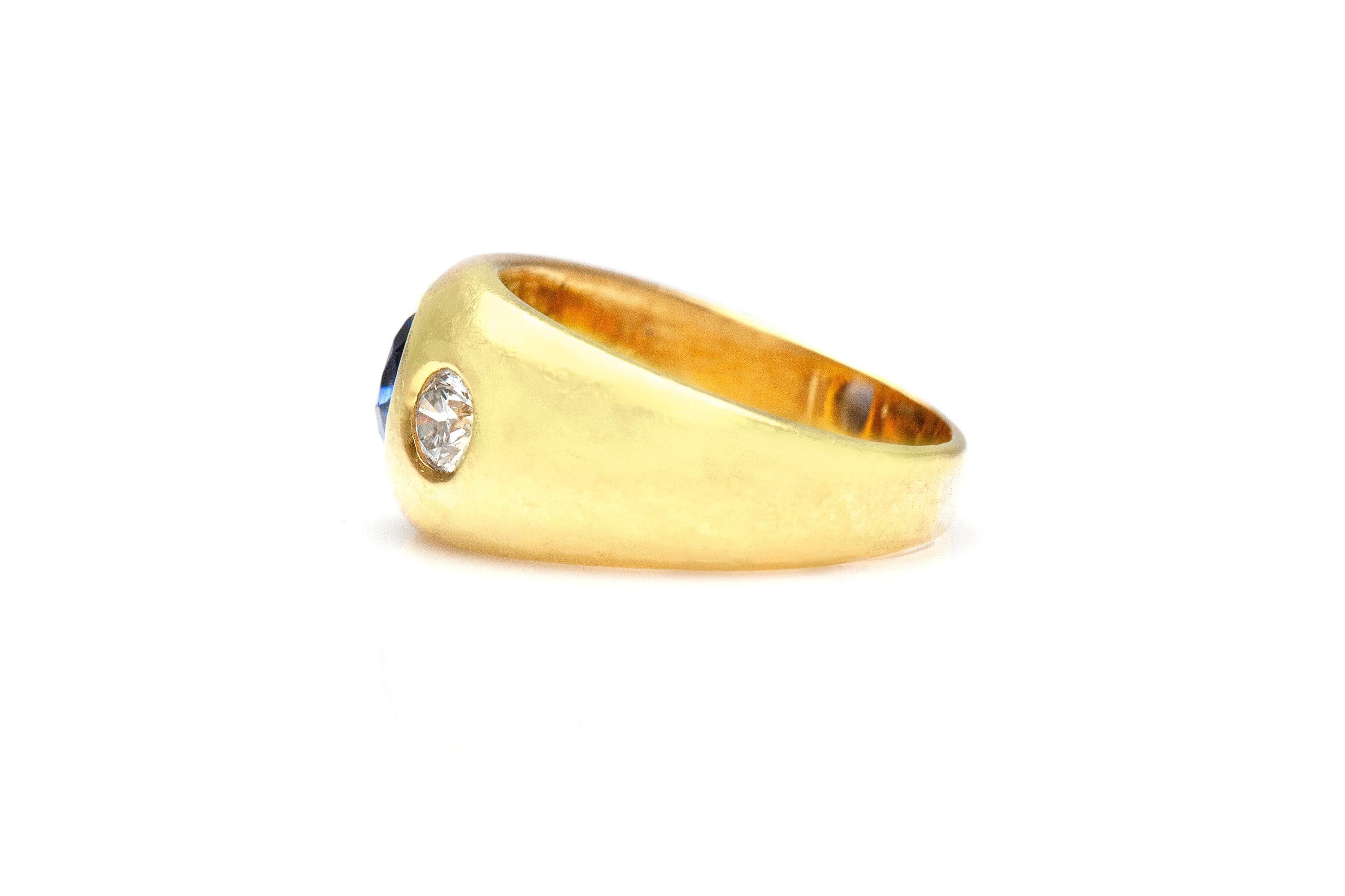 Finely crafted in 18K yellow gold with a center sapphire stone weighing 1.53 carats and two side diamonds weighing 0.36 carat each. Signed by Bvlgari.