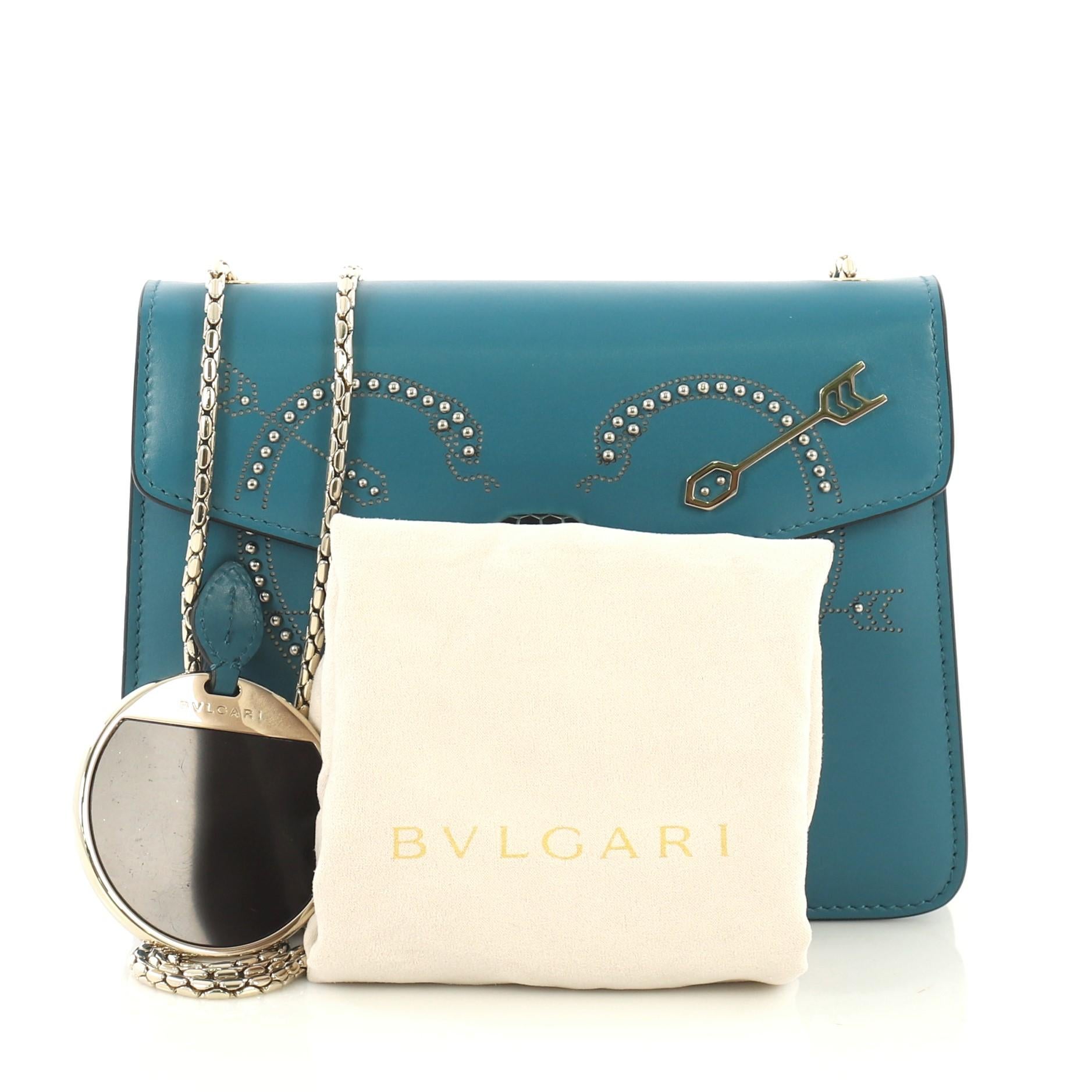 This Bvlgari Serpenti Forever Shoulder Bag Embellished Leather Small, crafted from blue embellished leather, features Serpenti head closure with malachite eyes and gold-tone hardware. It opens to a pink leather interior with side slip pocket.