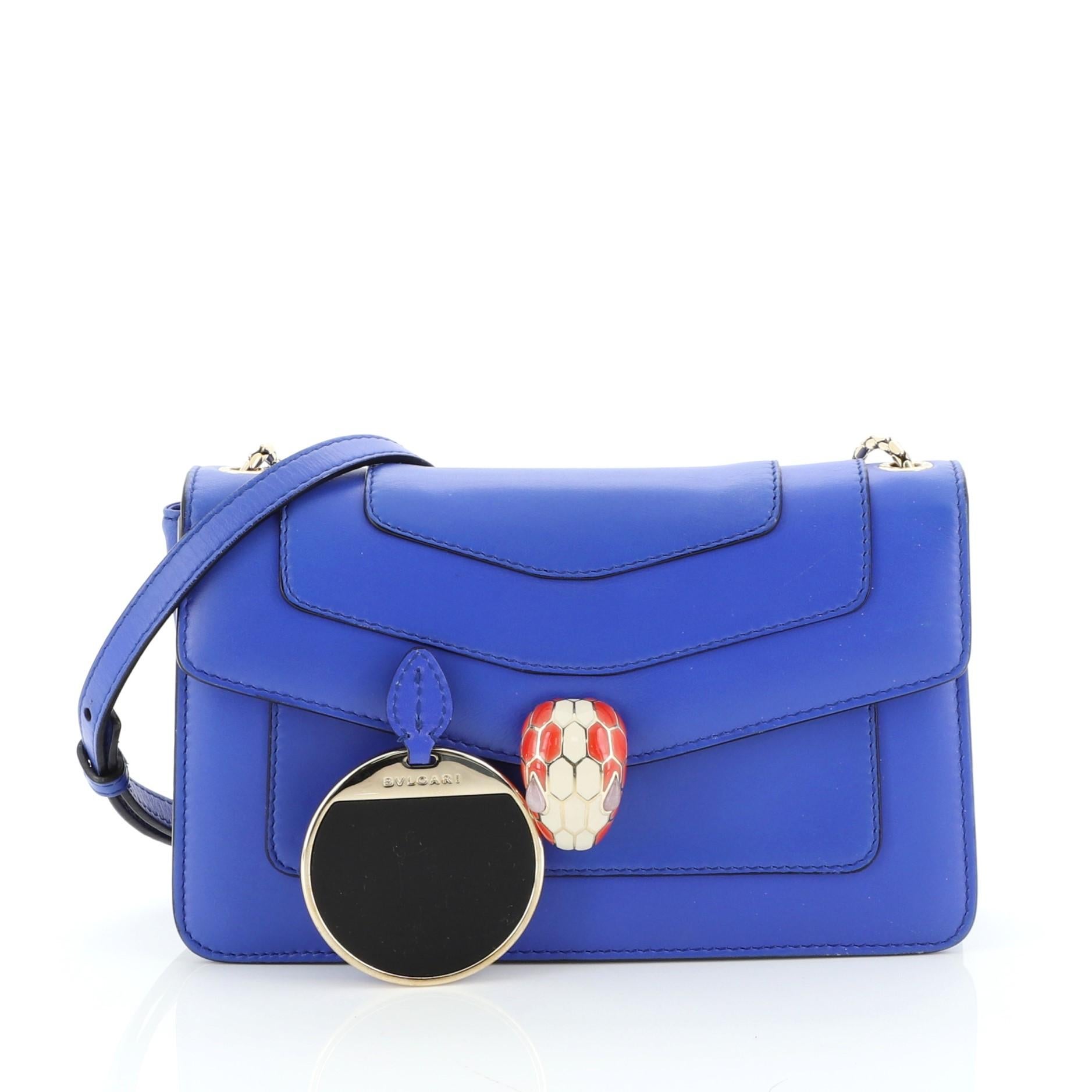 This Bvlgari Serpenti Forever Shoulder Bag Leather Small, crafted from blue leather, features a snake inspired chain strap and gold-tone hardware. Its serpenti head closure opens to a purple fabric interior with side slip pocket. 

Estimated Retail
