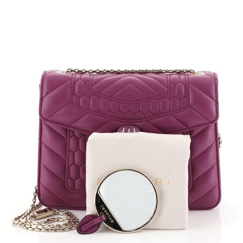 This Bvlgari Serpenti Forever Square Shoulder Bag Quilted Leather Small, crafted from purple quilted leather, features a snake inspired chain strap, Serpenti head closure with malachite eyes, and gold-tone hardware. Its flap opens to a pink leather