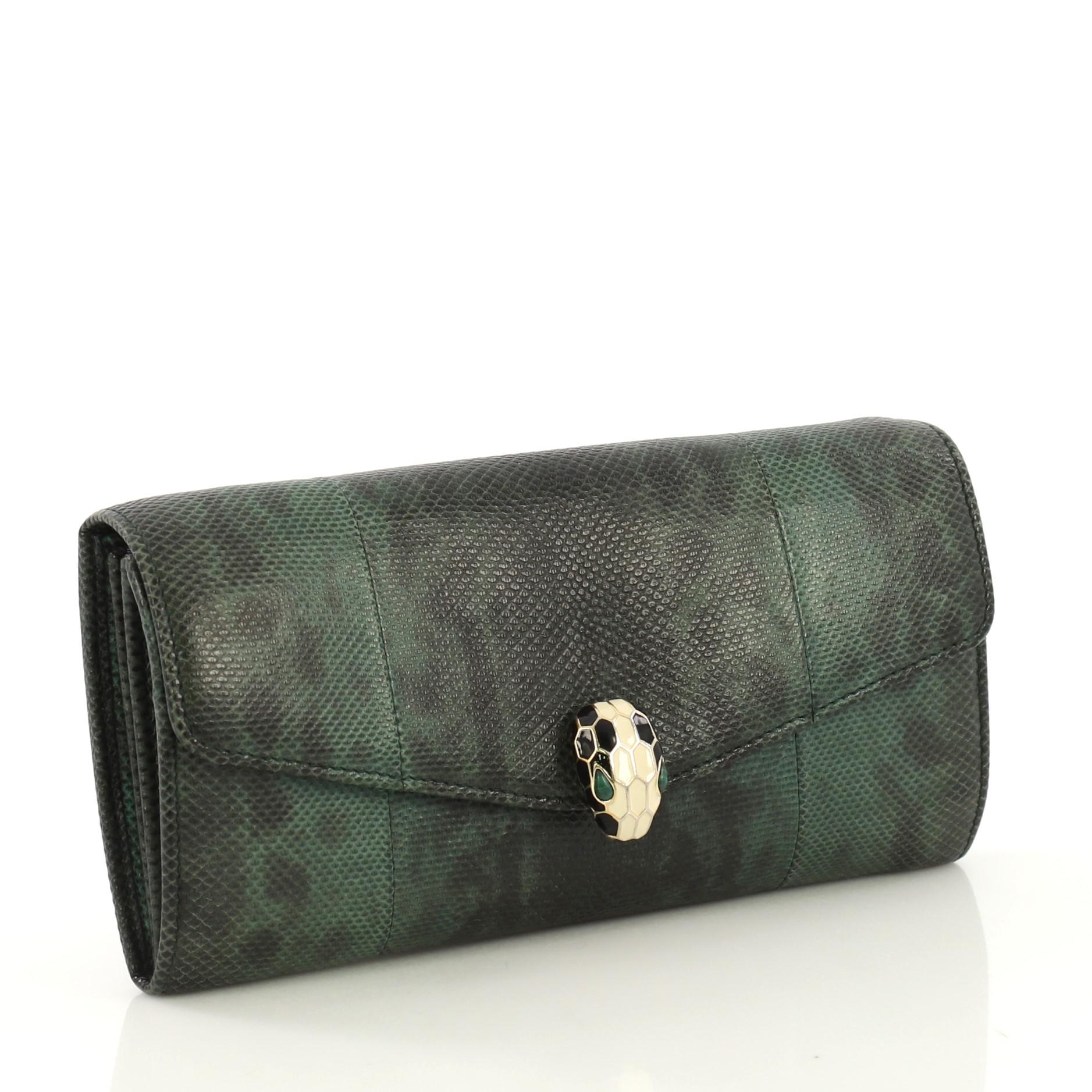 This Bvlgari Serpenti Forever Wallet Karung, crafted in green karung, features serpenti head closure with malachite eyes and gold-tone hardware. It opens to a purple fabric and green karung interior with multiple slip pockets and center zip