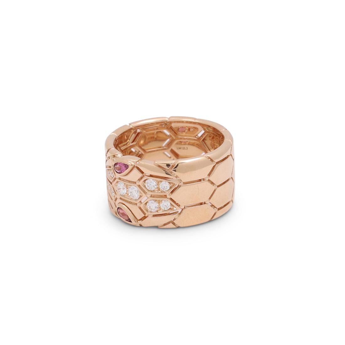 Authentic Bvlgari 'Serpenti Seduttori' ring crafted in 18 karat rose gold. A new take on the brand's iconic snake design, the wide band features a distinctive snakeskin pattern and snake head set with rubellite eyes. The ring is finished with 12