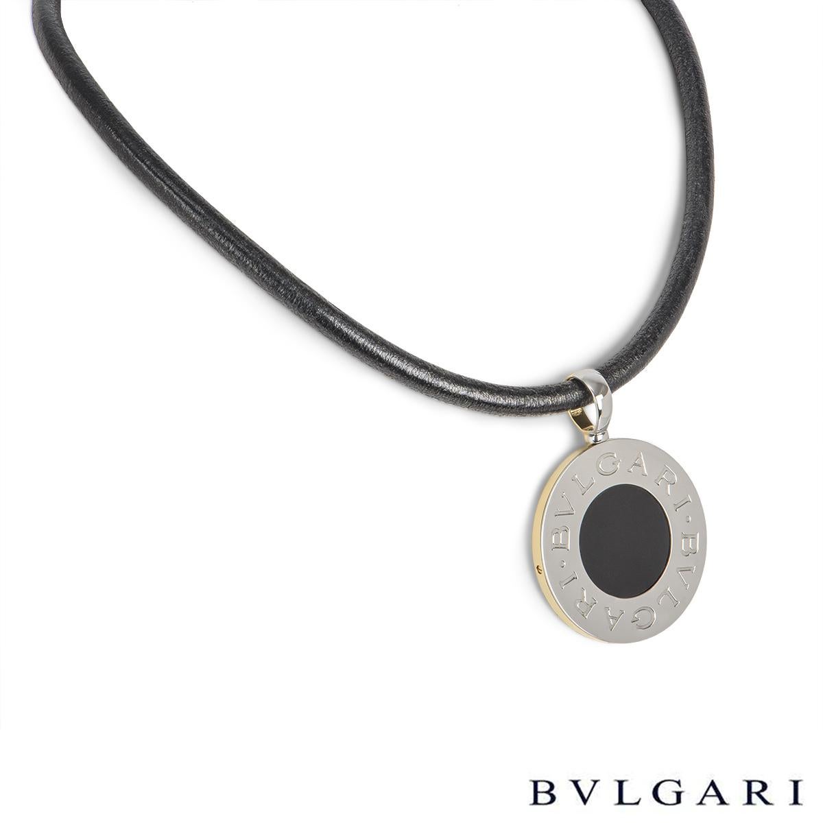 An iconic 18k yellow gold and stainless steel reversible Tondo pendant by Bvlgari. The pendant is set to the centre with an onyx disc with the Bvglari motif around the outer edge. The pendant comes complete on the original 14 inch Bvlgari black cord