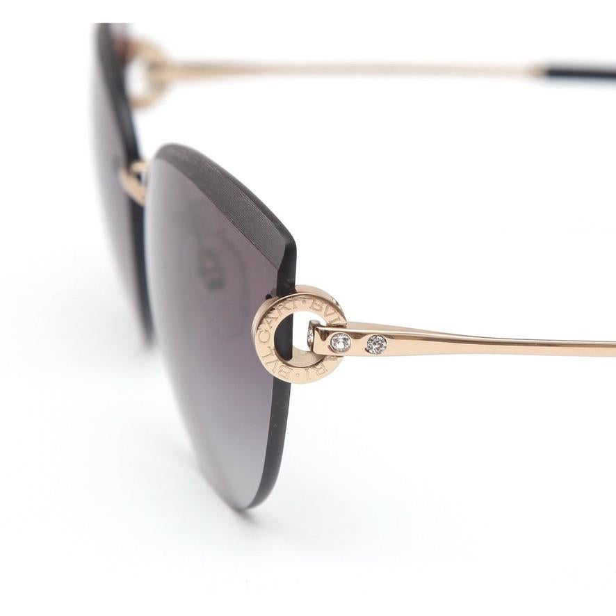 GUARANTEED AUTHENTIC BVLGARI CAT EYE SHAPED RIMLESS SUNGLASSES
BV6166B 2014/8G


Details: 
- Rimless cat eye shaped lens.
- Grey gradient lens.
- Gold-toned arms.
- Logo with crystals at corners.
- Comes with sunglass dust bag, case and box.
- Lens