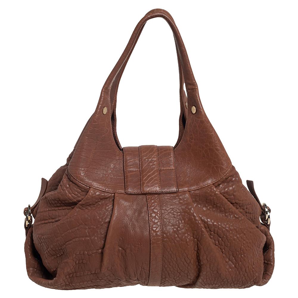 A known style from the house of Bvlgari, Chandra is loved for its comfortable silhouette and elegant appeal. This Tan one is meticulously crafted from leather and has the signature slouchy shape with broad pleats, dual top handles, and a front