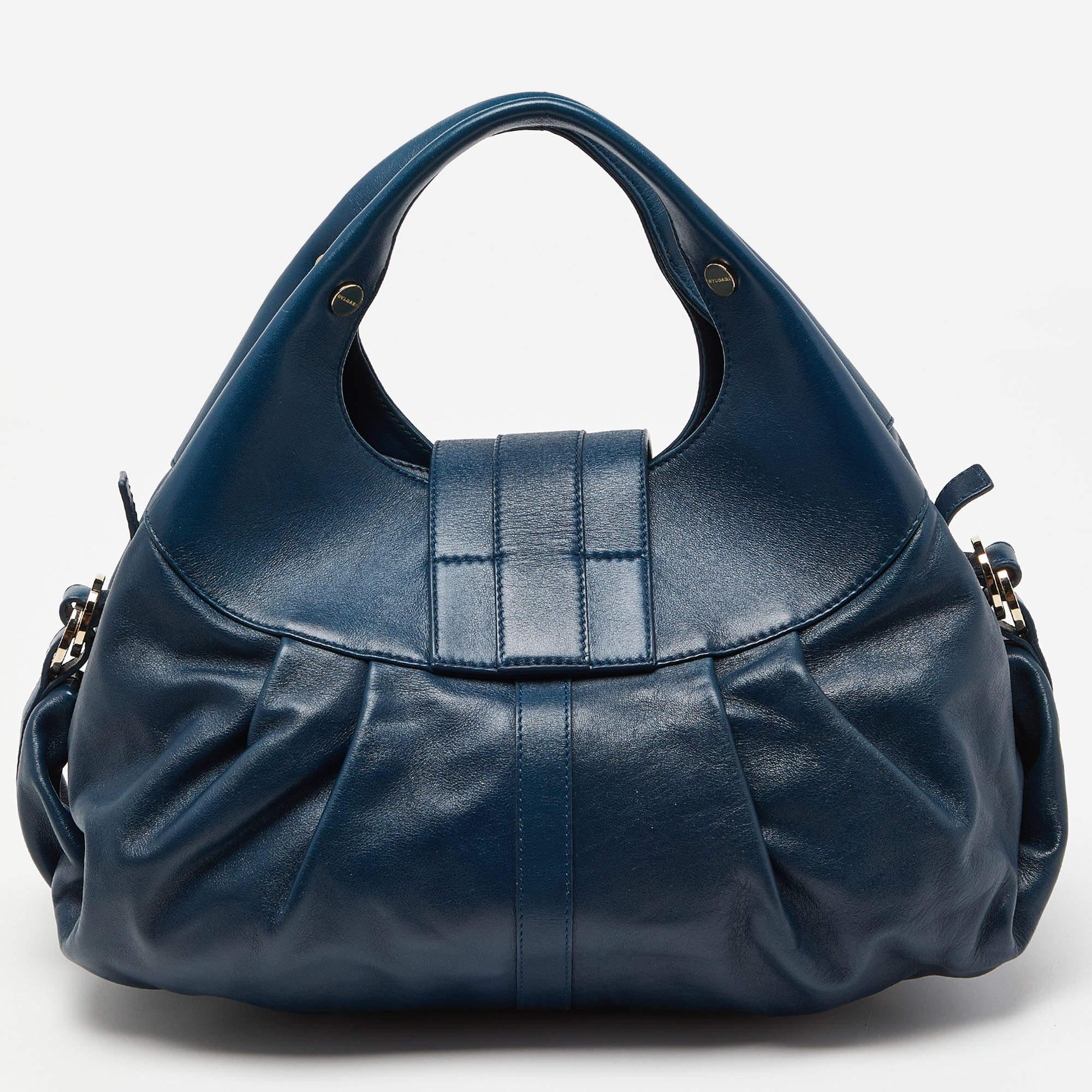 A known style from the house of Bvlgari, Chandra is loved for its comfortable silhouette and elegant appeal. This teal-hued one is meticulously crafted from leather and has the signature slouchy shape with broad pleats and dual top handles. The bag