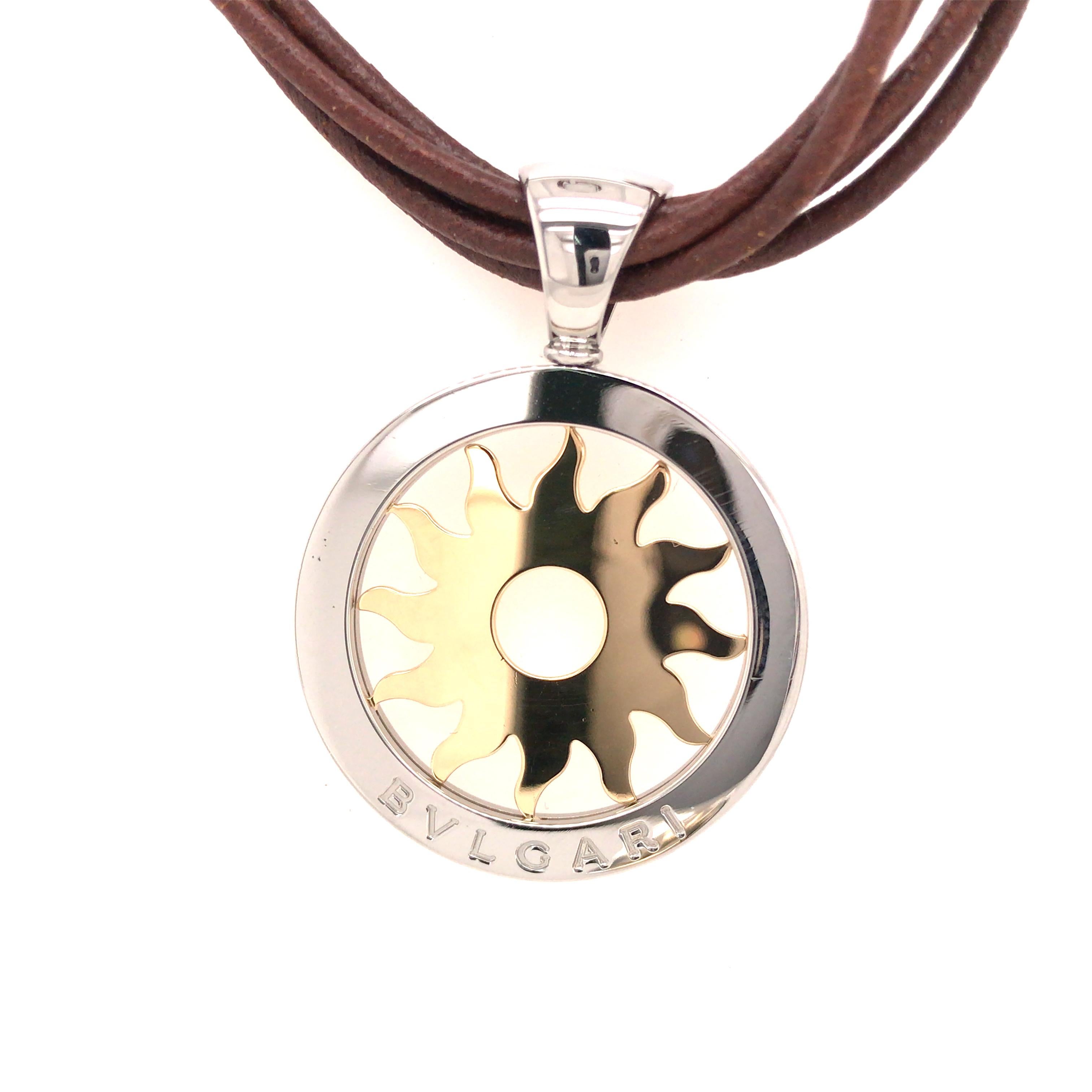 Bvlgari Tondo 18K Yellow Gold and Steel Sun Pendant Leather Cord Necklace.  The Necklace measures 15 inch in length. 23.9 grams.  Inscribed 