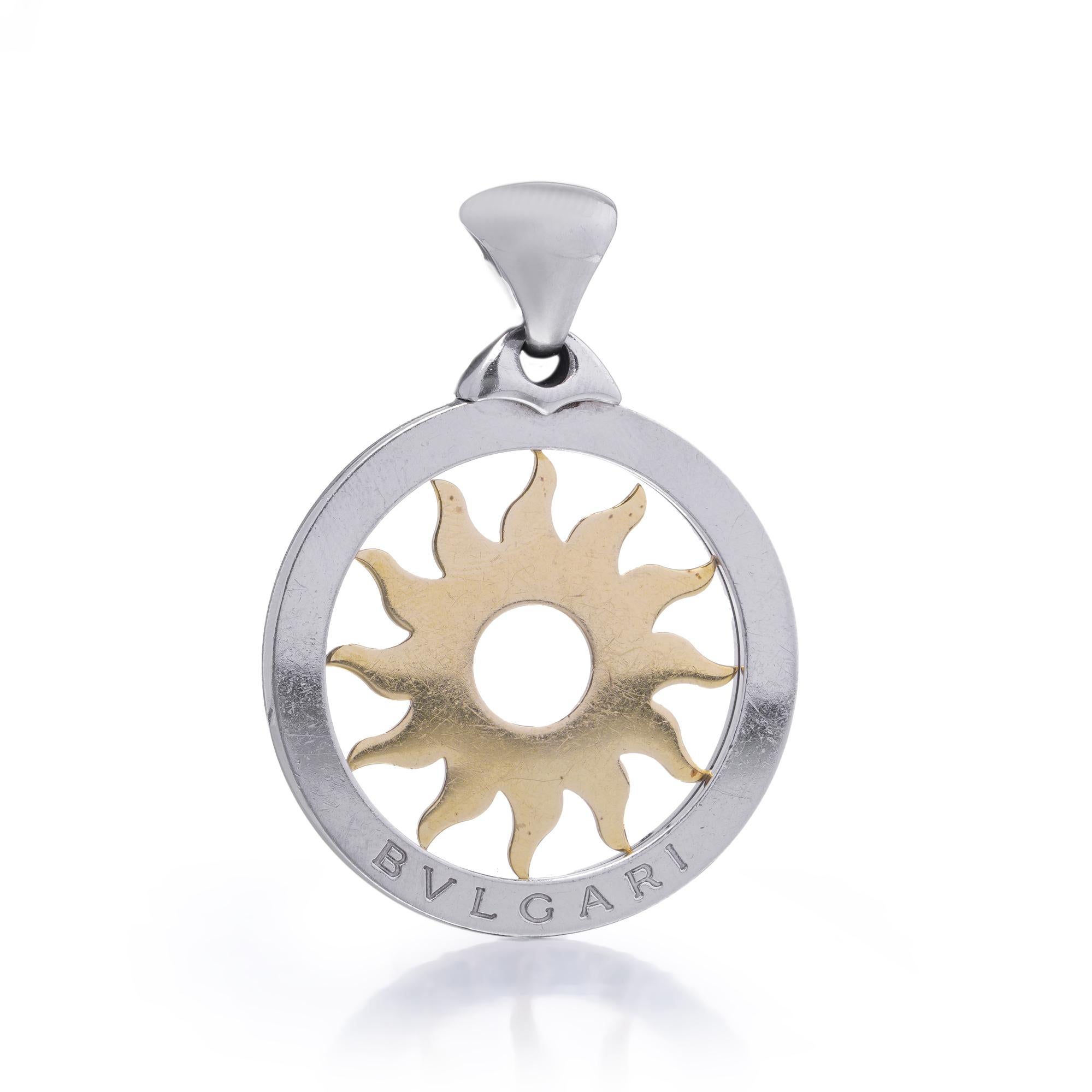 A bold and iconic Bvlgari Tondo Soleil pendant, crafted in stainless steel with a radiant sun motif in 18kt yellow gold. The openwork design features Bvlgari’s signature engraved logo on the outer circular frame, framing the central stylised sun