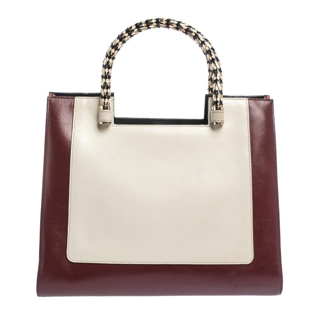 Bvlgari's Serpenti collection has stunning creations and this tote is a fine example. Crafted from quality leather, this tri-color Serpenti Scaglie tote is styled with retractable dual snake handles and gold-tone hardware. The bag comes with a