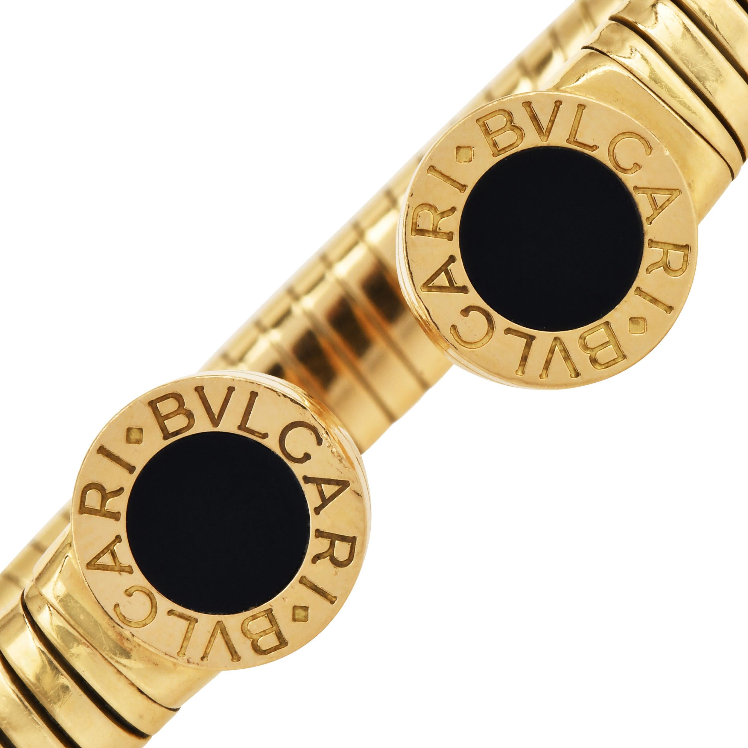 Este brazalete vintage Bvlgari Tubogas es un icono atemporal de la artesanía italiana. Con elegantes incrustaciones redondas de ónice enmarcadas en oro amarillo pulido de 18 quilates, el flexible diseño Tubogas envuelve la muñeca con elegancia y
