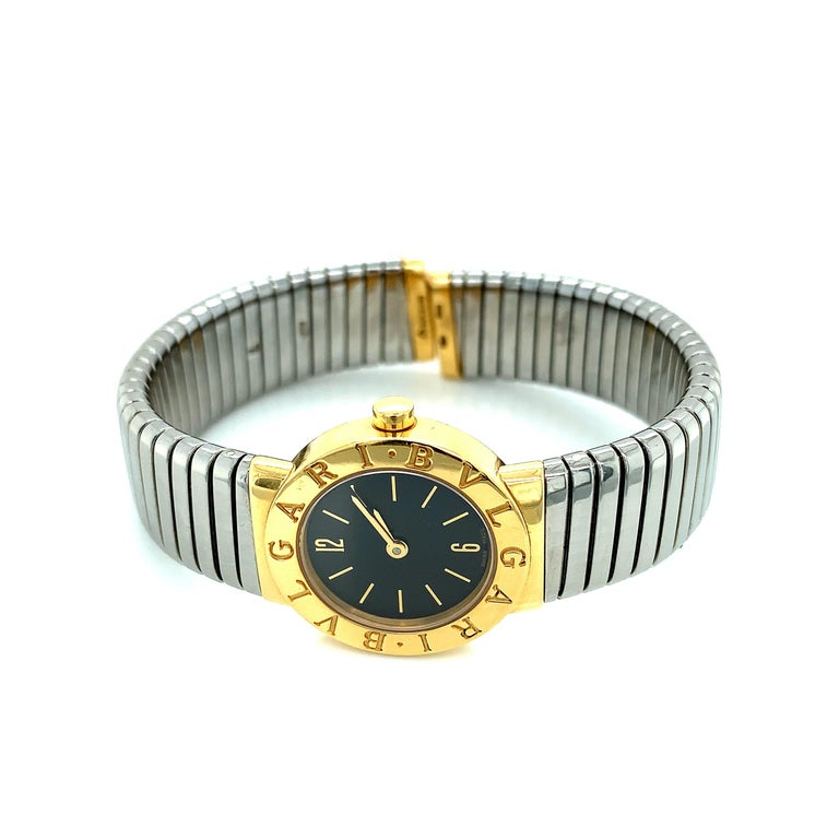 Bvlgari Tubogas bracelet watch, featuring a Swiss-made quartz movement; black dial with gold hands and hour markers; and 23mm, 18 karat yellow gold and stainless steel case with an 18 karat yellow gold bezel on a 'Tubogas'-style, stainless steel
