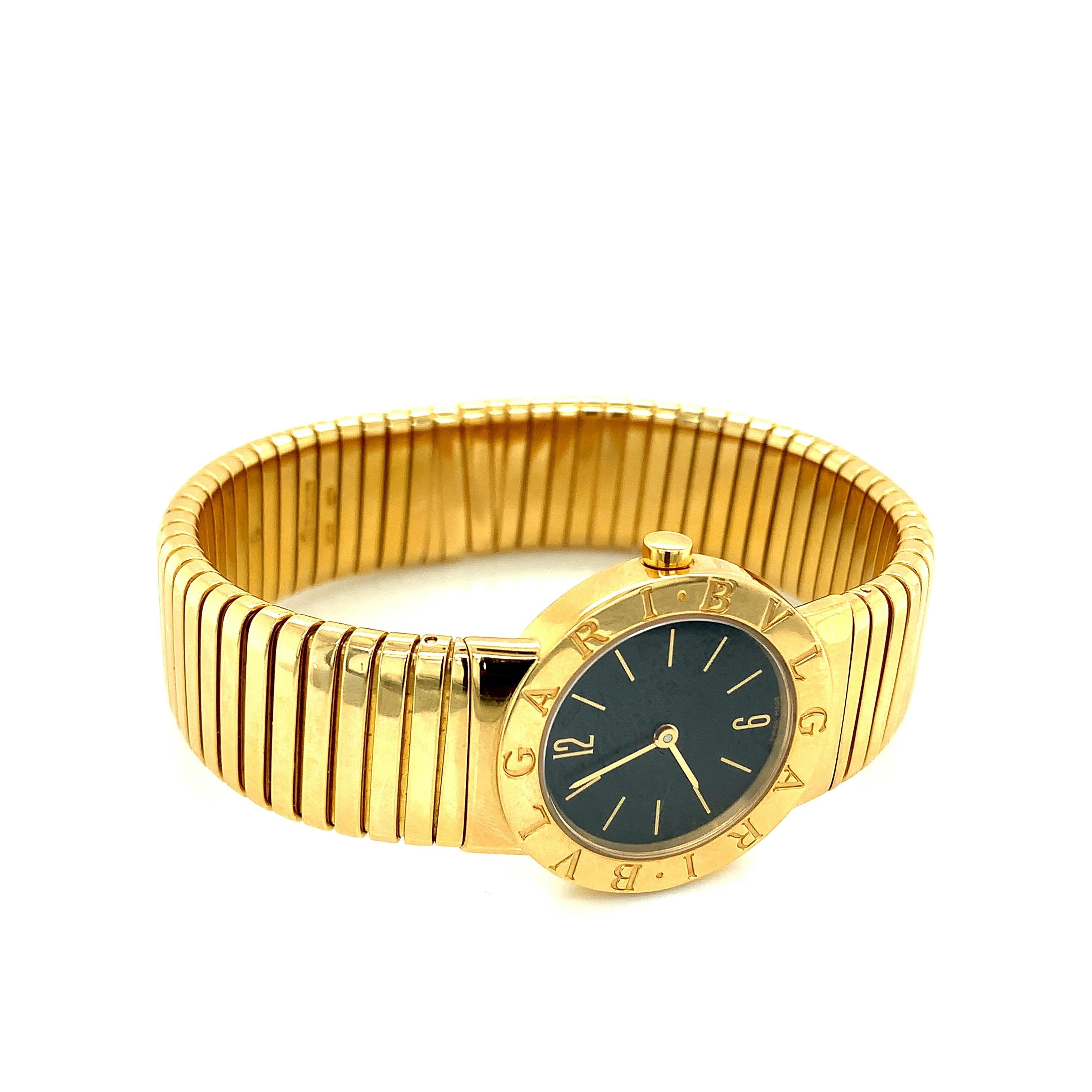 Orologio bangle Bvlgari in oro 18 carati dell'iconica collezione Tubogas. Prodotto in Svizzera. Il bracciale aperto presenta un quadrante nero rotondo al centro, con capitoli a bastone e numeri arabi al dodici e al sei. Il movimento è al quarzo.