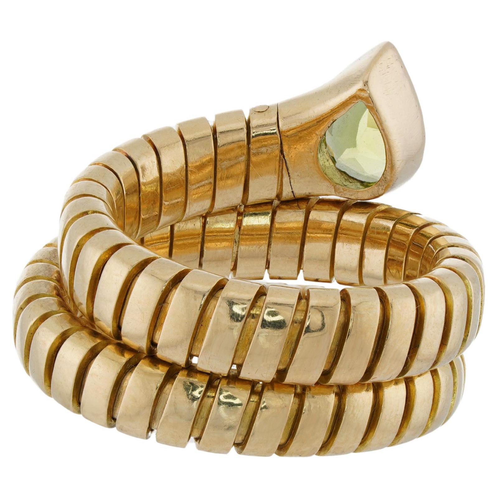 This fabulous authentic Bvlgari ring from the classic Tubogas collection is crafted in 18k yellow gold and set with a pear-cut peridot. The flex wrap allows the ring size to be slightly adjustable . Made in Italy circa 1980s. Measurements: 0.70
