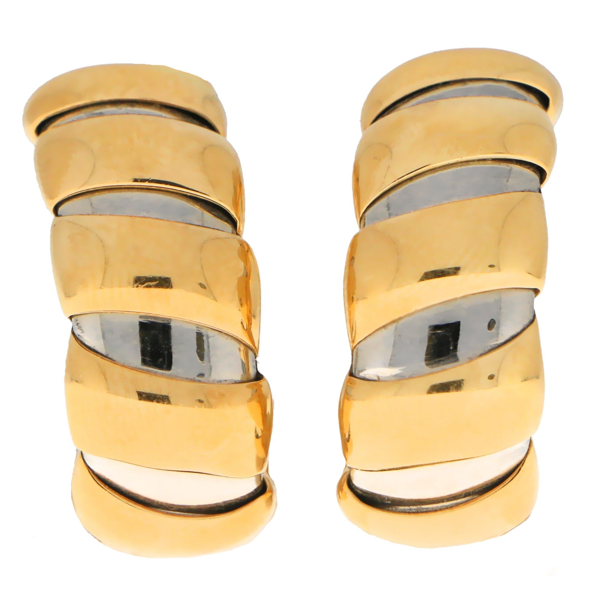 A lovely pair of Bvlgari Tubogas earrings set in 18k yellow gold and stainless steel. 

Each earring is composed of 8 polished yellow gold pipe bands on top of a flexible stainless steel half hoop. The contrast of the yellow gold against the steel