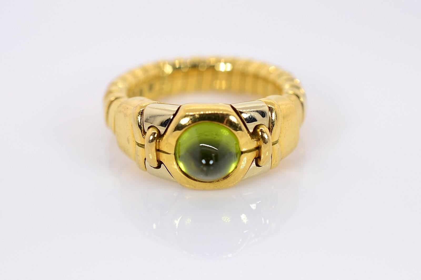 A wonderful gift to oneself!  This everyday wear Bvlgari Tubogas adjustable 18KT gold ring flaunting a cabochon green Tourmaline.  The clever design of adjustable fit from size 5 to 8 makes the ring a versatile piece of jewelry.  The band is stamped