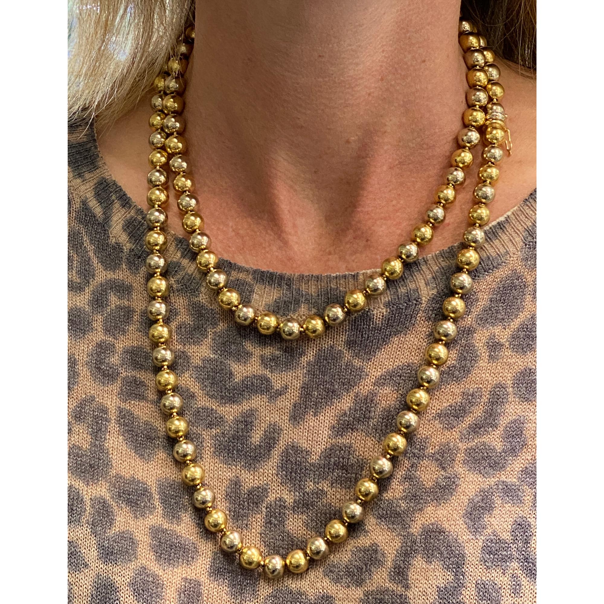 Rare Bvlgari vintage bead necklace circa 1960's. This fabulous 40 inch necklace features 18 karat yellow and white 8mm gold beads, and a clasp (signed Bvlgari on the clasp). The necklace can be worn long or doubled up. The beads are all in excellent