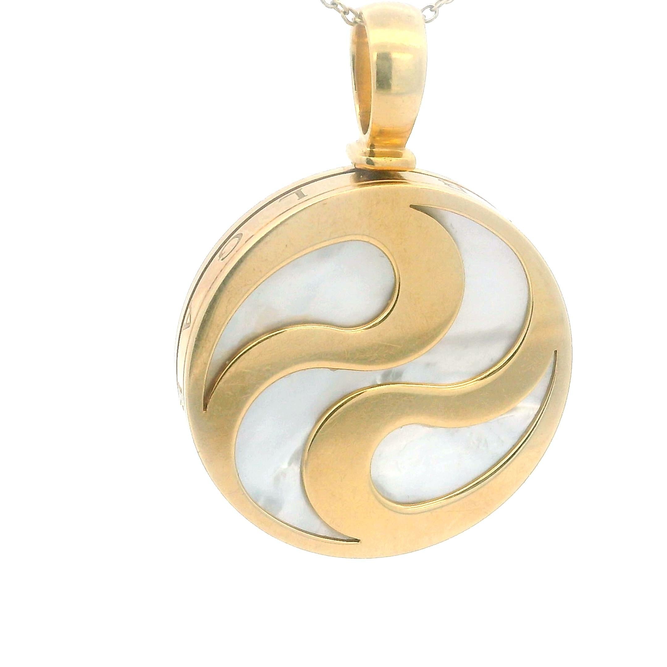 Exceptionnel pendentif vintage de Bvlgari, magistralement réalisé en or jaune 18 carats et incrusté de nacre brillante. Le design circulaire audacieux de la 