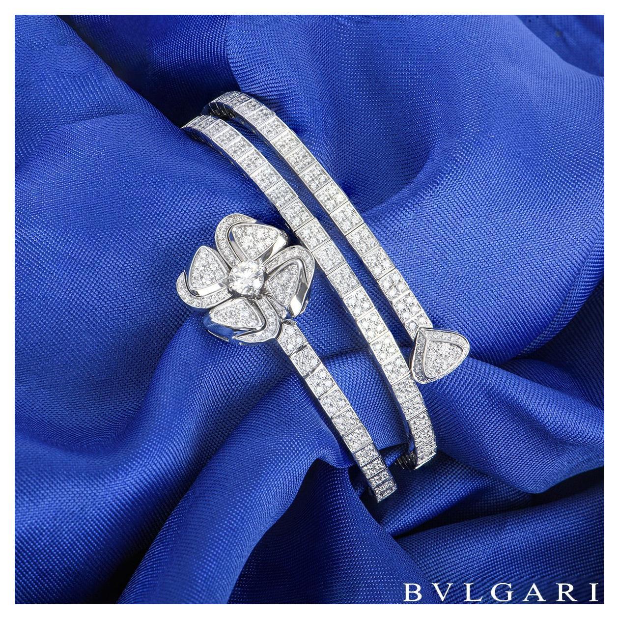 An alluring 18k white gold diamond bracelet by Bvlgari from the Fiorever collection. The bracelet coils around the wrist with a flower motif at one end and a single petal motif at the other. The bracelet is set with 515 round brilliant cut diamonds