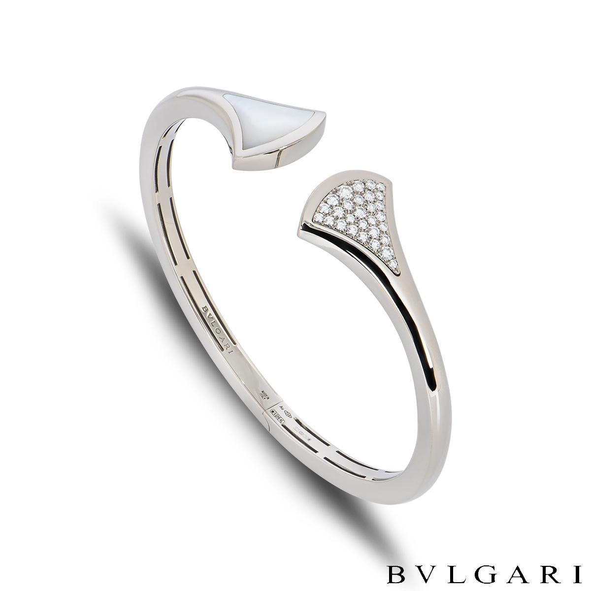 An elegant 18k white gold Bvlgari diamond and mother of pearl bracelet from the Divas' Dream collection. The cuff style bracelet has a fan-shaped motif on either end, one pave set with 29 round brilliant cut diamonds totalling approximately 0.42ct,
