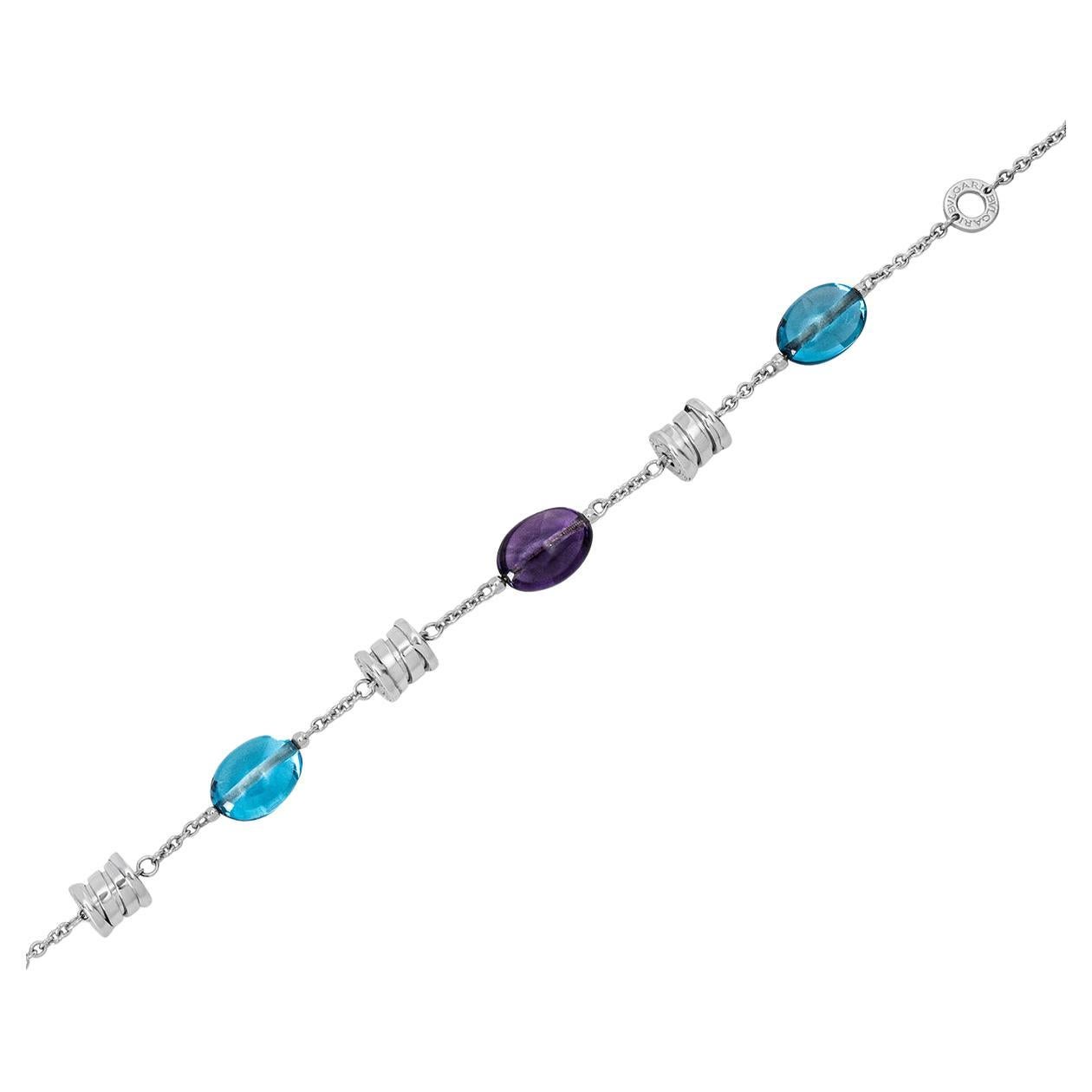 A chic 18k white gold multi-gem bracelet by Bvlgari from the B.zero1 collection. The bracelet comprises of two amethyst and two topaz beads alternating with three 'Bvlgari Bvlgari' barrels. The bracelet features a lobster clasp and has an adjustable