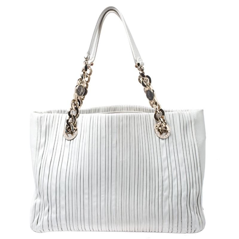 Fall in love almost instantly with this excellent handbag by Bvlgari. The soft pleated leather of this shopping tote makes it a pleasure to use. It comes in a lovely shade of white. The purple fabric lining has an open pocket and a zippered wall