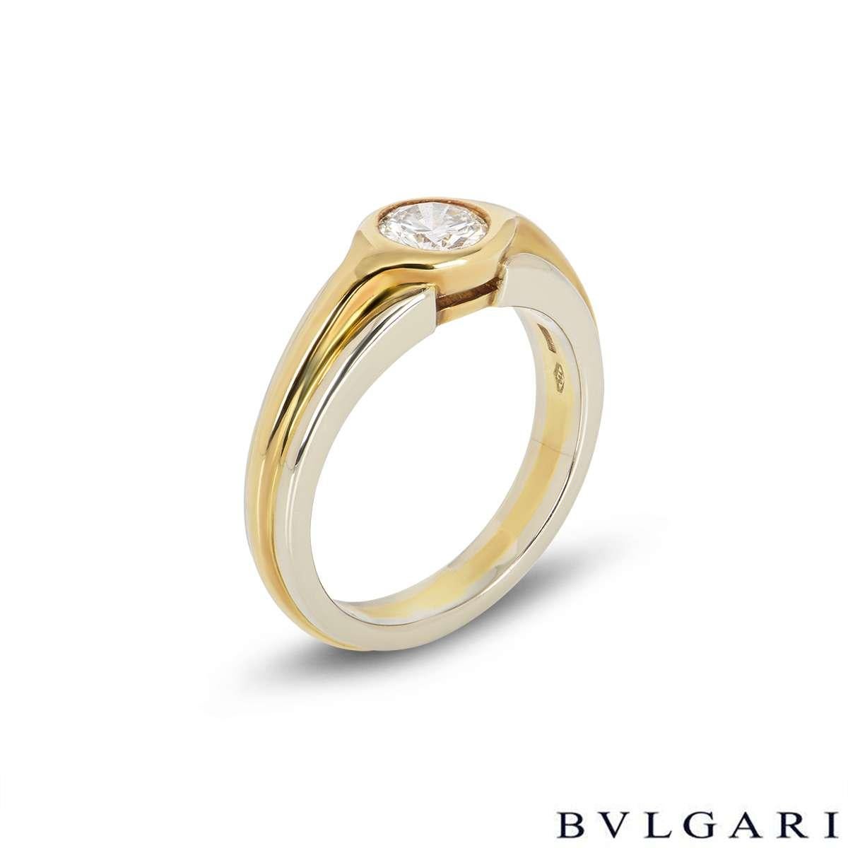 A unique 18k white and yellow gold Bvlgari diamond engagement ring. The ring comprises of a 0.50ct, H colour and VS clarity round brilliant cut diamond in a rubover setting. The ring features yellow gold and white gold band and measures a size UK L½