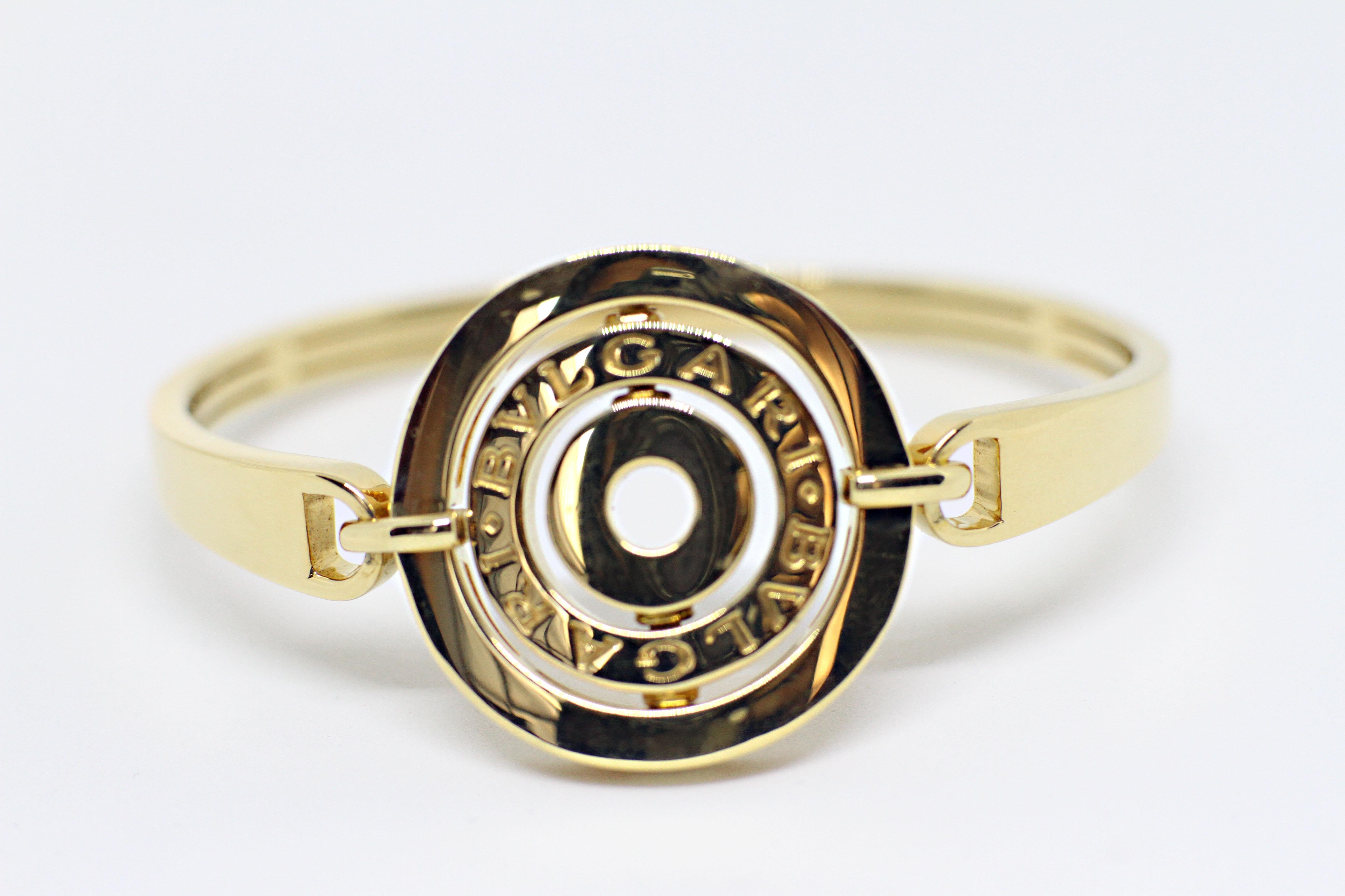 Bvlgari yellow gold bangle from the Astrale collection. Three  central independent rings with a moving interior ring engraved ' Bvlgari', all attached to a sectional bangle. Hallmarked  Italian 18 carat yellow gold. Comes with Bvulgari cushioned