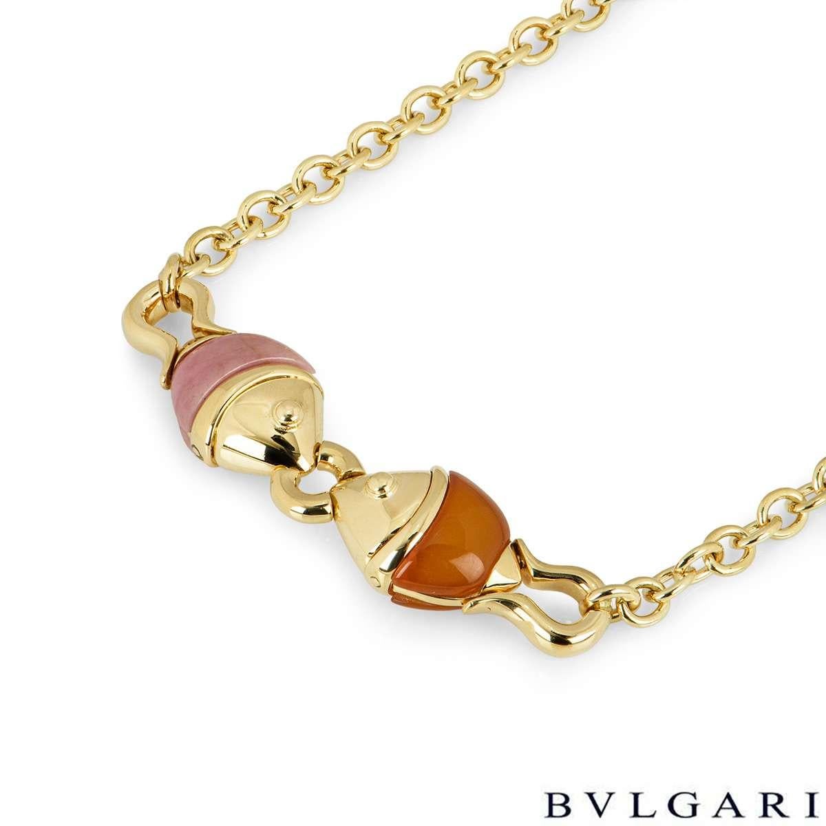 An 18k yellow gold necklace from the Naturalia collection by Bvlgari. The necklace features two fish facing each other, one is set with carnelian and the other is set with pink jade. The necklace measures 16inches in length and features a lobster
