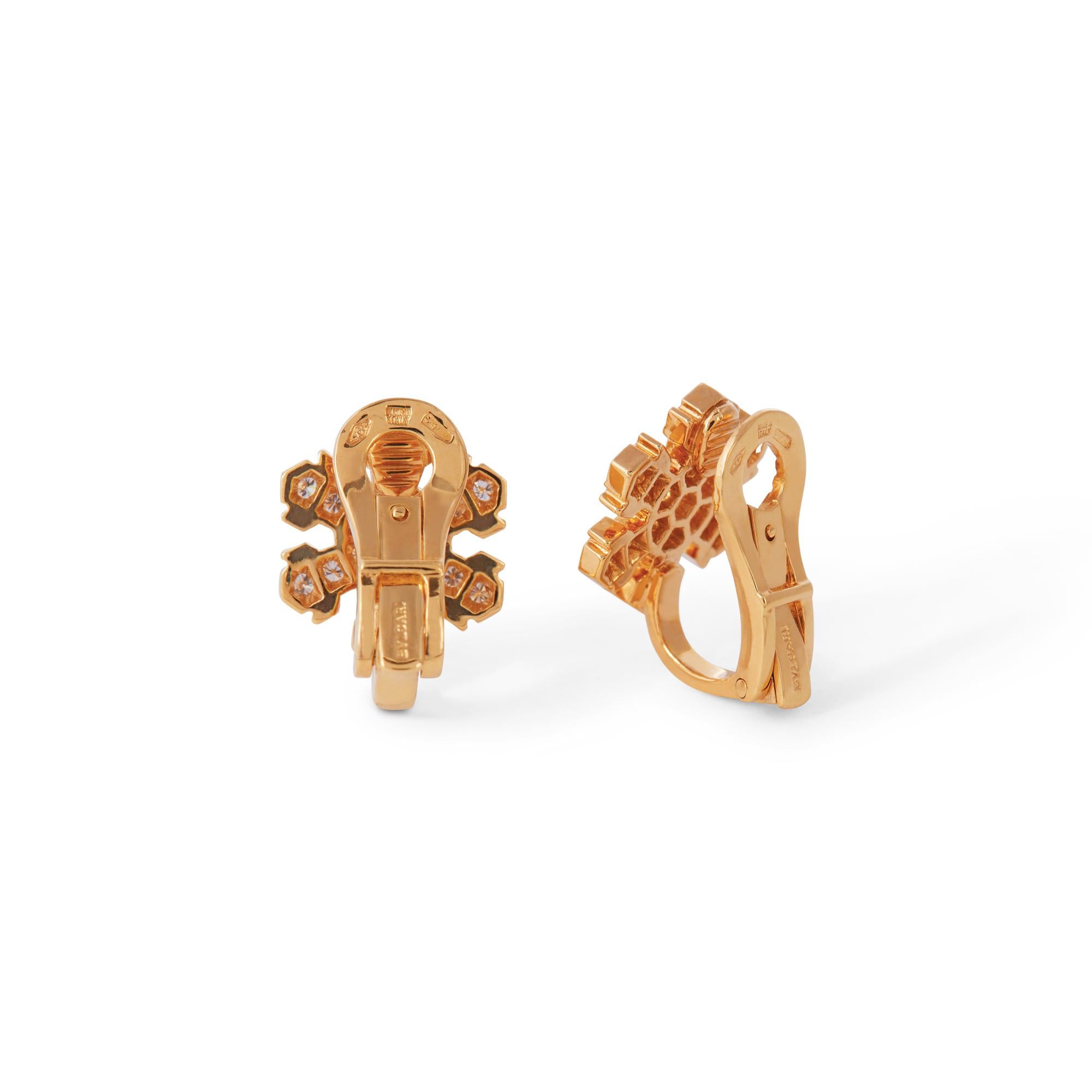 Authentic Bvlgari earrings crafted in 18 karat yellow gold.  The snowflake-shaped earrings are set with round brilliant cut diamonds for an estimated .50 carats total weight.  The earrings measure 14mm in length and 12.1mm wide with clip backs for