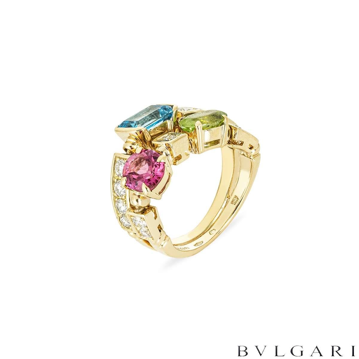 A beautiful 18k yellow gold multi-gem ring from the Allegra Coriandoli collection by Bvlgari. The ring is in a split design and separated into two rows, set to the first row with a rectangular blue topaz 1.30ct and to the second row with a round