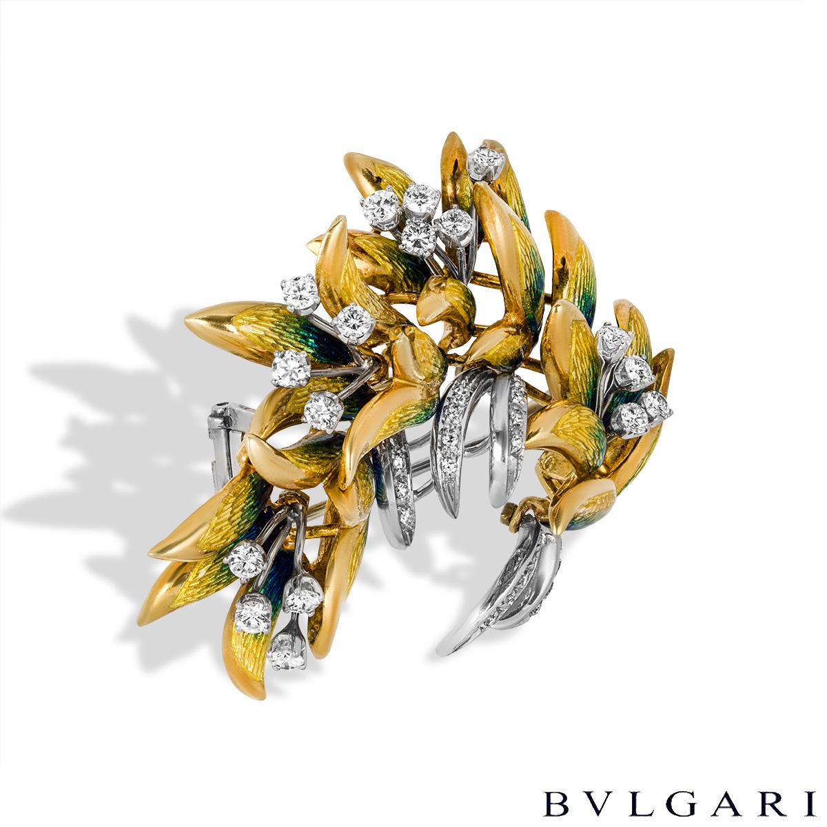 A unique bi-colour gold enamel and diamond brooch by Bvlgari. The brooch features four yellow gold floral motifs adorned with a blue to yellow ombre enamel. Set to the centre of the flowers are 17 round brilliant cut diamonds with an approximate