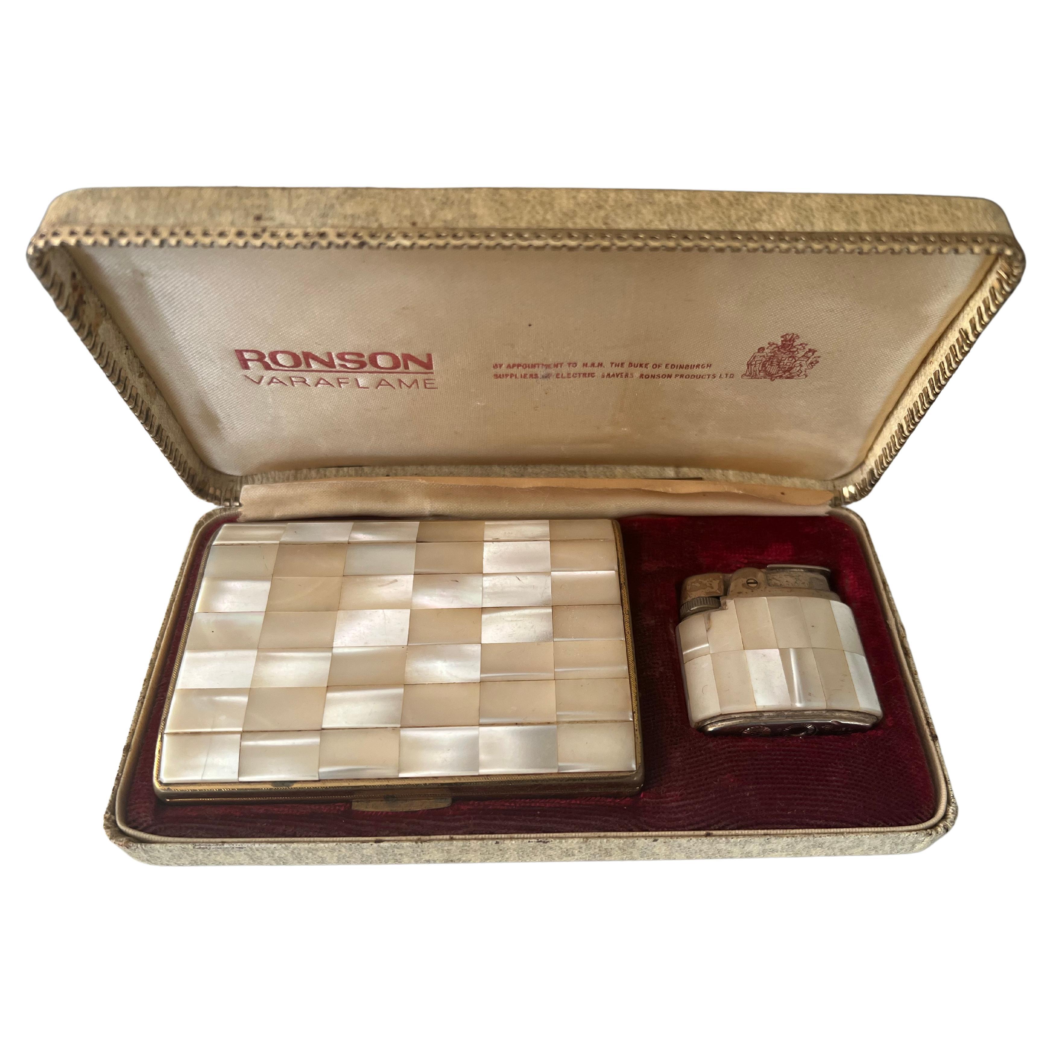 This is a Ronson Varaflame set that consists of a lighter and matching cigarette case. 
By Appointment To H.R.H The Duke Of Edinburgh, 
The case has a lid that is covered in a patchwork of genuine mother of pearl. The interior has an arm in one side