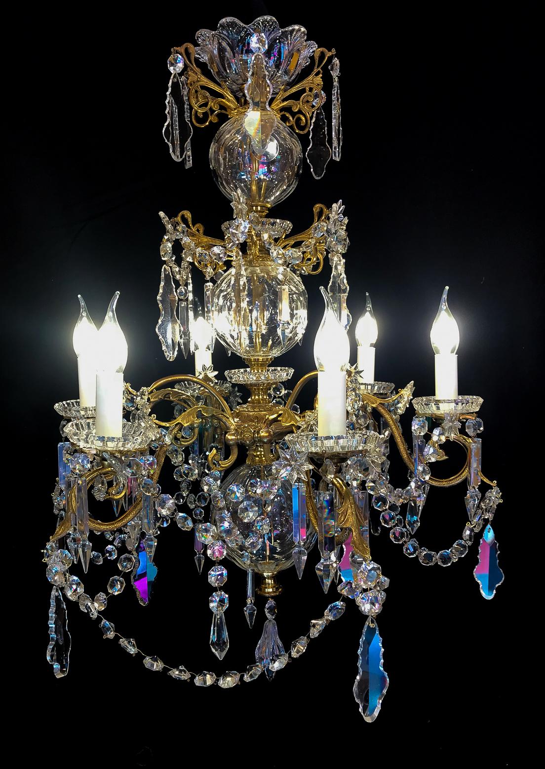 We are pleased to present you, a rare and elegant gilt bronze and cut-crystal, chandelier. 
Our chandelier is composed of six perimeter arm lights. Excellent white cut-crystal pieces, balls, plaques and one cut crystal bell.

Excellent quality in