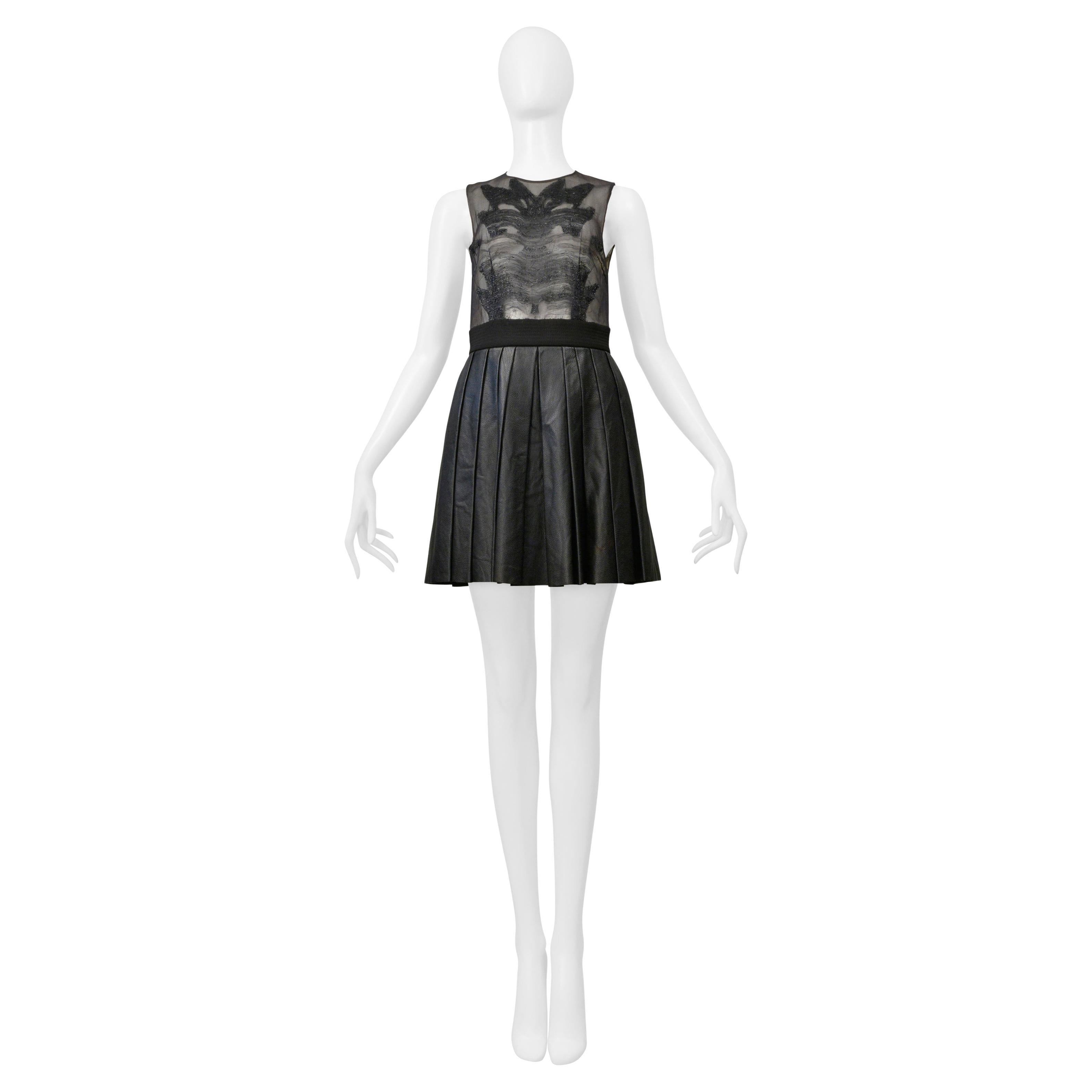 Byblos Minivestido negro con parte superior transparente y falda de piel plisada en venta